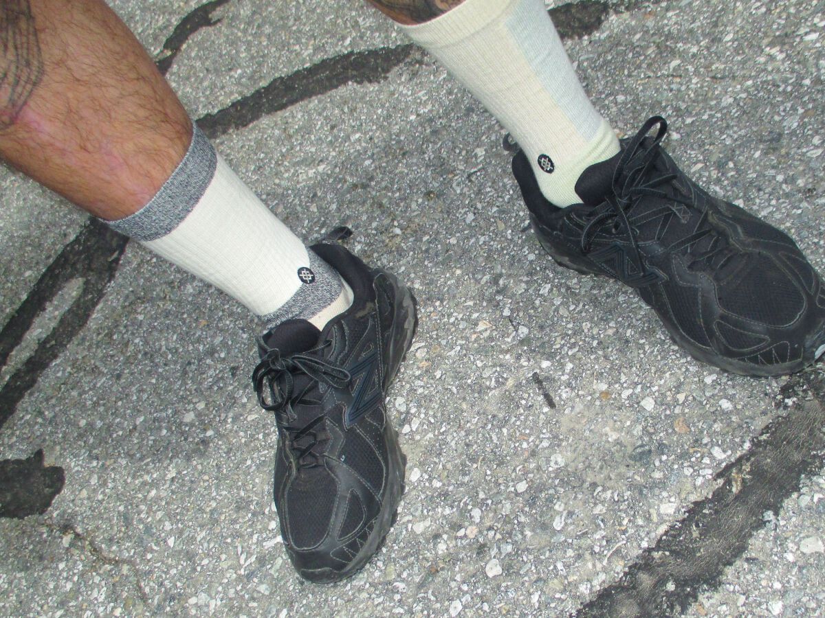 photo of a model wearing butter blend crew socks standing on concrete.